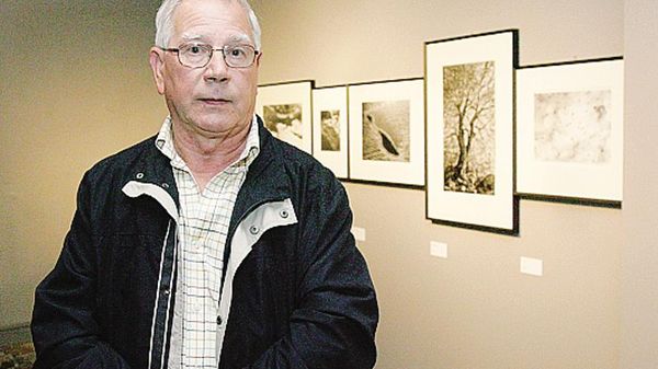 Alberto Bianchi posa davanti ad alcune delle sue foto in mostra 