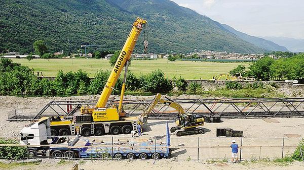 La gru impegnata nella posa del ponte tra le due sponde del Bitto