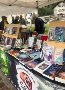 1 Uno degli stand di “Libri in Valle” 2025, la rassegna culturale che dal 2024 si tiene a Campodolcino, dopo l’inizio itinerante nel 2019.2 La copertina de “L’eco dei sussurri”, l’ultima fatica editoriale dello scrittore valchiavennasco Gabriele Dolzadelli.3 Gabriele Dolzadelli, autore locale, si ispira ai suoi luoghi del cuore per la scrittura dei suoi libri
