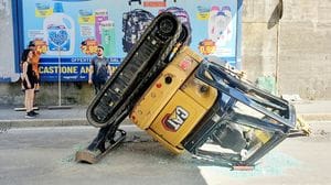 Escavatore scivola dal cassone di un camion in transito a Sondrio